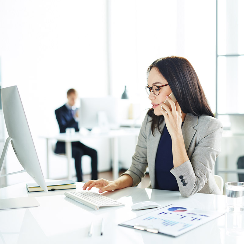 Businesswoman speaking on the phone and browsing online